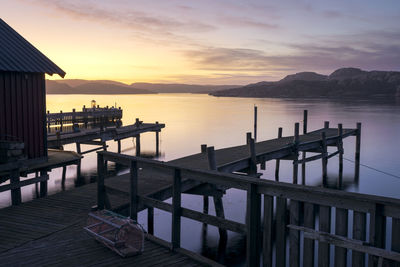 Pier over sea against sky during sunset