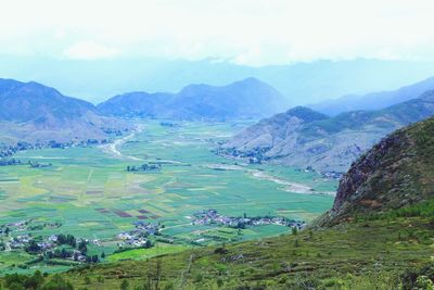 Scenic view of field and mountains against sky