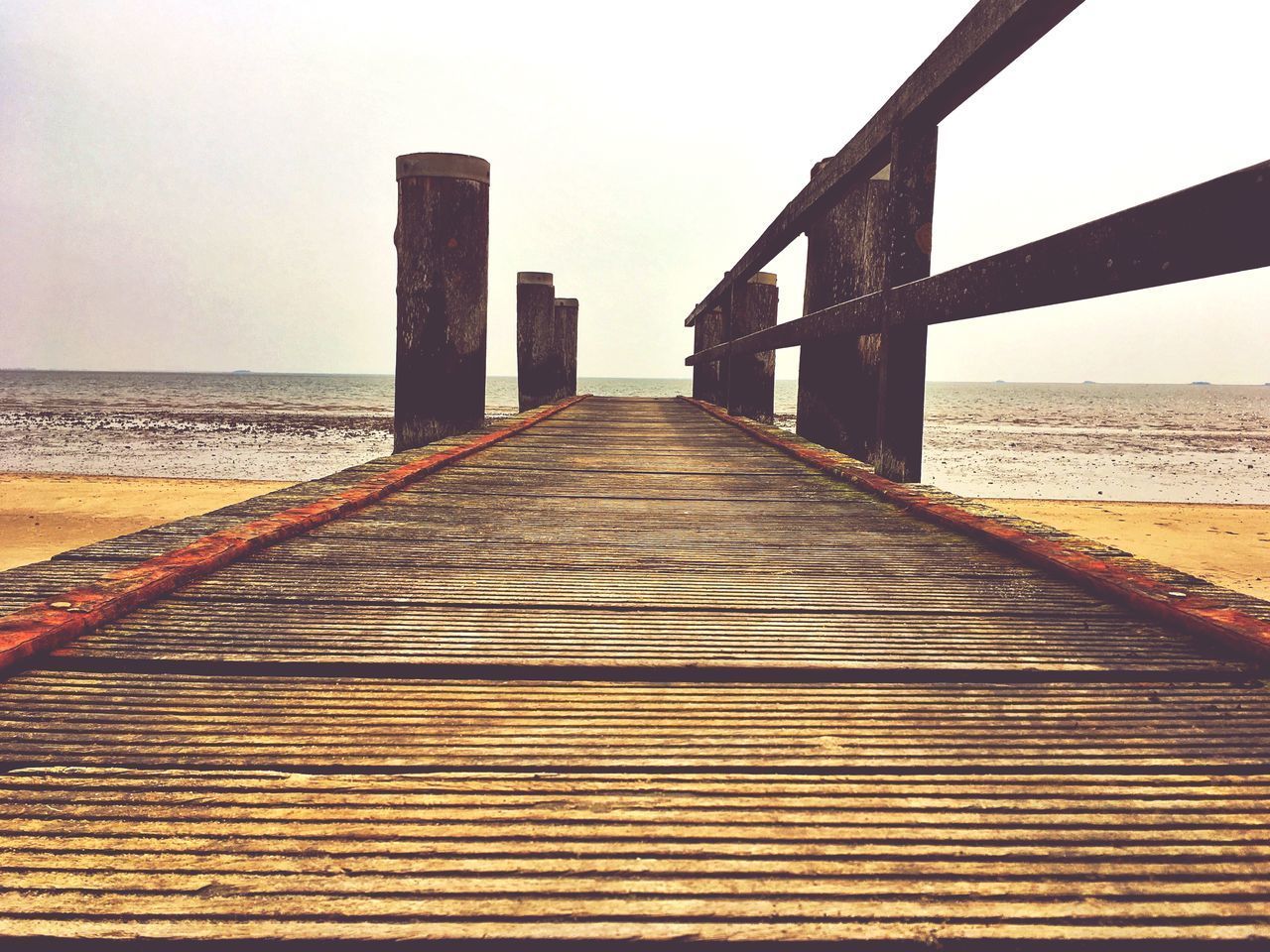PIER LEADING TOWARDS SEA AGAINST SKY