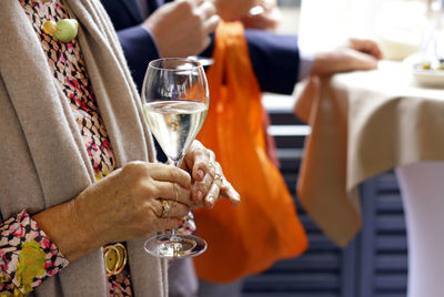 Lifestyle of the wealthy - senior woman holding champagne flute at an event