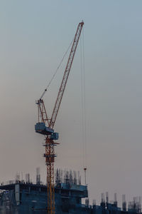 Cranes at construction site against sky