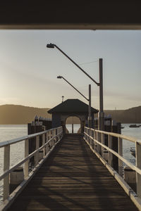Pier over sea against sky during sunset