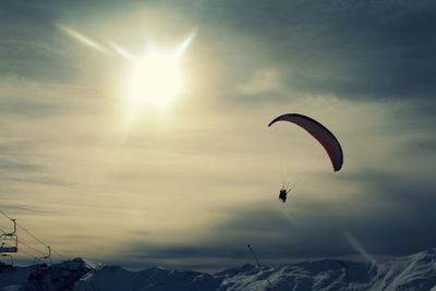 Low angle view of parachute flying over mountain