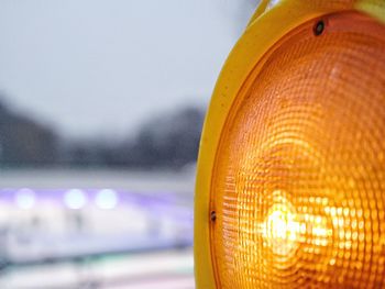 Close-up of illuminated lighting equipment against sky