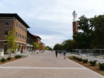 Rear view of man walking on road in city