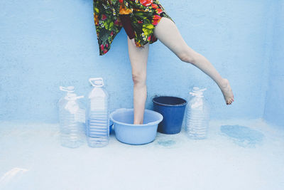 Woman standing in empty bucket inside swimming pool