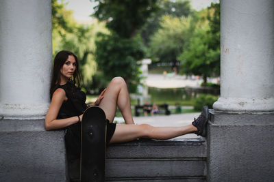 Portrait of young woman sitting outdoors