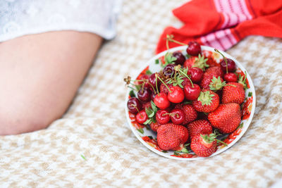 Midsection of woman holding strawberries