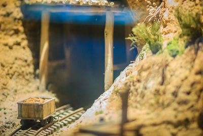 Close-up of small container on rock against wall