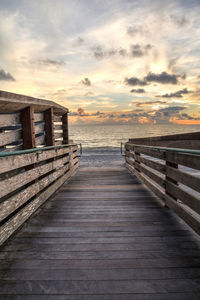 Pier over sea against sky during sunset