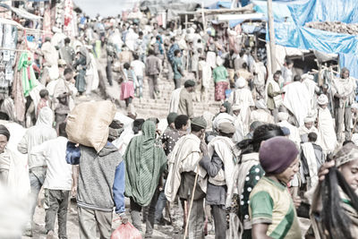 Rear view of people walking on street in city