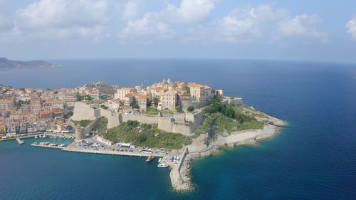 High angle view of townscape by sea against sky