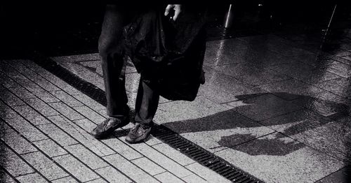 Low section of man standing on tiled floor