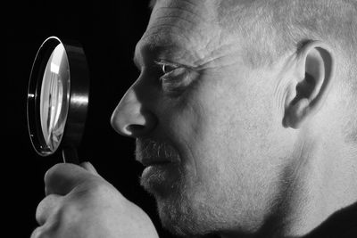 Close-up of man with magnifying glass