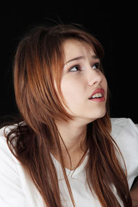 Portrait of beautiful young woman over black background