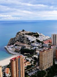 High angle view of cityscape by sea against sky