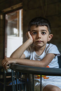 Portrait of boy sitting on chair