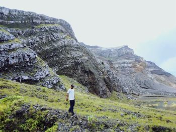 Full length of man standing on rock against sky