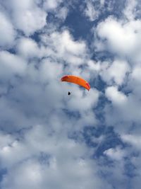 Low angle view of person paragliding against sky