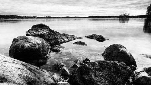 Scenic view of rocks at beach against sky