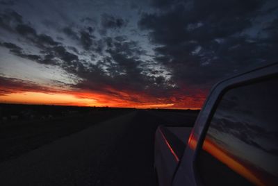 Car on road against sky at sunset