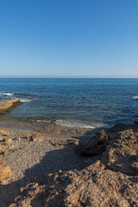 Scenic view of sea against clear blue sky