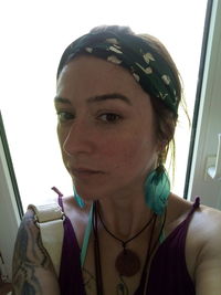 Portrait of young woman looking through window