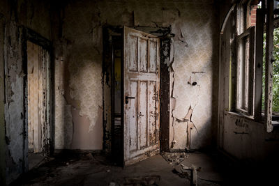 Damaged door and window in abandoned building