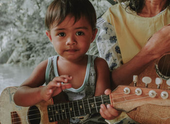 Portrait of boy playing guitar