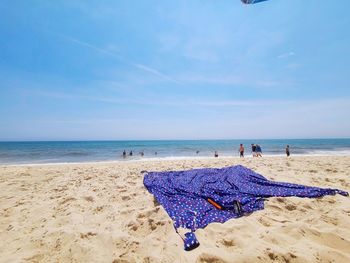 Deck chairs on beach against blue sky