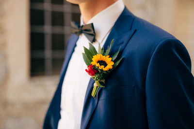 Midsection of man holding flower