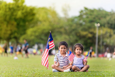 Boy and son flag on grass