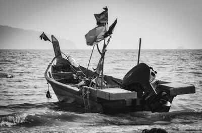 Fishing boat on shore against clear sky