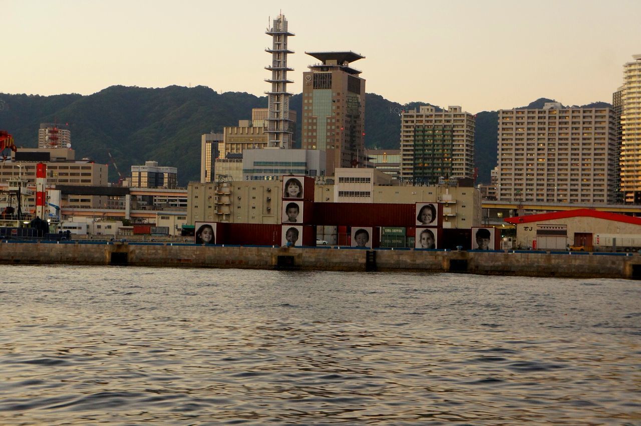 VIEW OF RIVER WITH CITY IN BACKGROUND