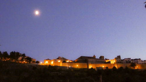 Illuminated buildings against sky at night