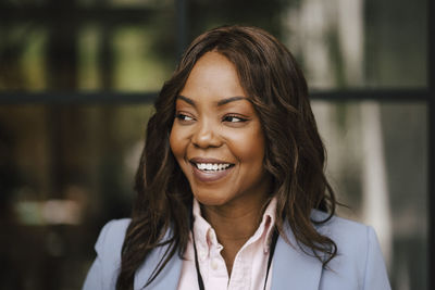 Smiling female professional with brown hair looking away