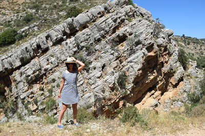 Woman standing against rock formation