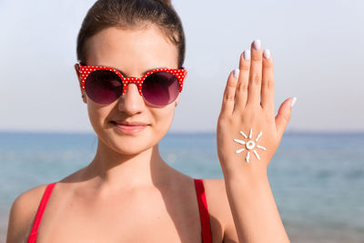 Portrait of woman wearing sunglasses against sea