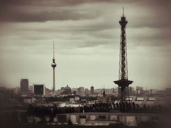 Silhouette of cityscape against cloudy sky