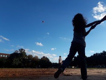 People playing soccer against sky