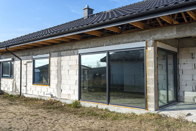 Newly installed not opened window with roller shutters in the house under construction.