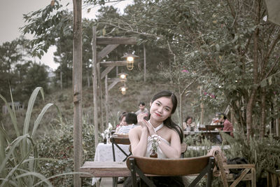 Young woman using mobile phone while sitting at park