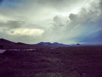 Scenic view of mountains against cloudy sky