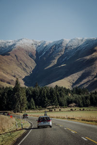 Cars on road against mountain range