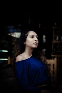 Young woman looking away while standing outdoors