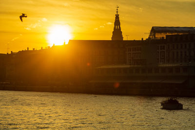 View of buildings at waterfront during sunset