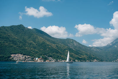 Scenic view of sea by mountains against sky