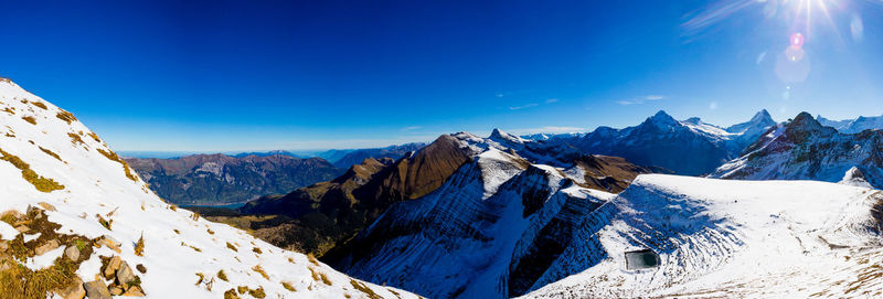 Panoramic view of snowcapped mountains against blue sky