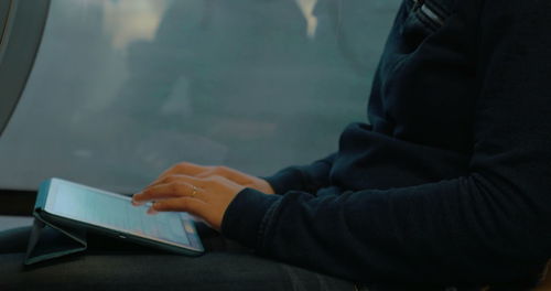 Midsection of man using mobile phone on table