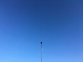 Low angle view of street light against clear blue sky